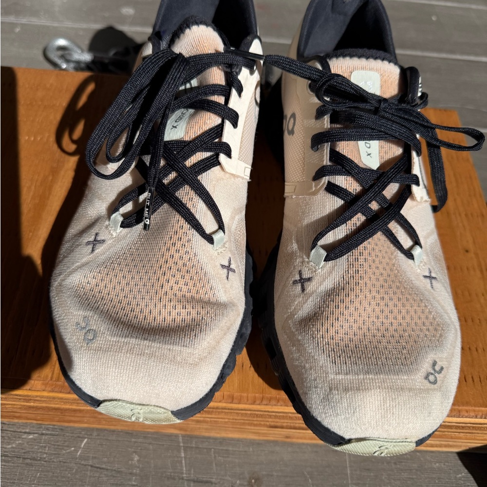 On Running Cream and Black Athletic Shoes